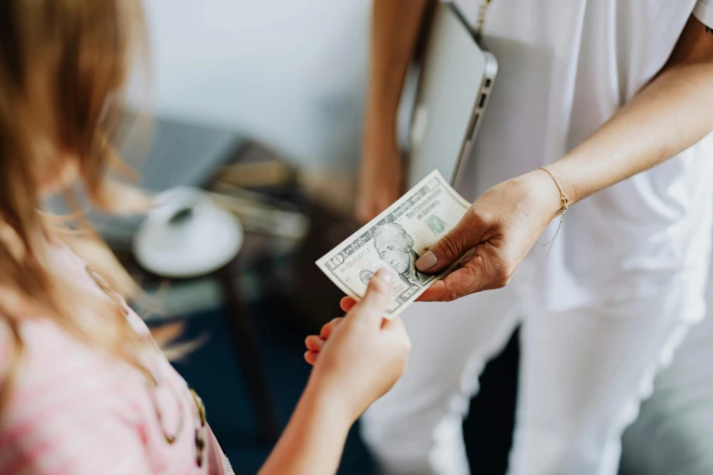 a woman handing a dollar to another woman, by Emma Andijewska, pexels contest winner, avatar image, family friendly, loosely cropped, ad image