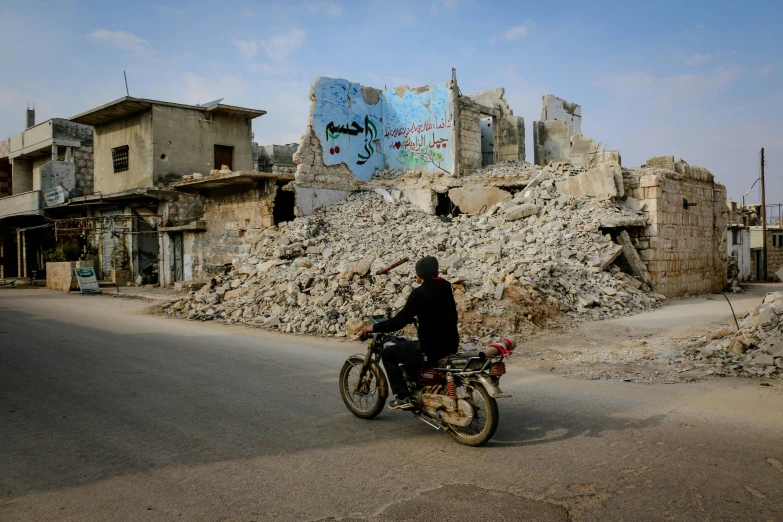 a man riding a motorcycle past a pile of rubble, zaha hadi, photograph taken in 2 0 2 0, ruined town, getty images