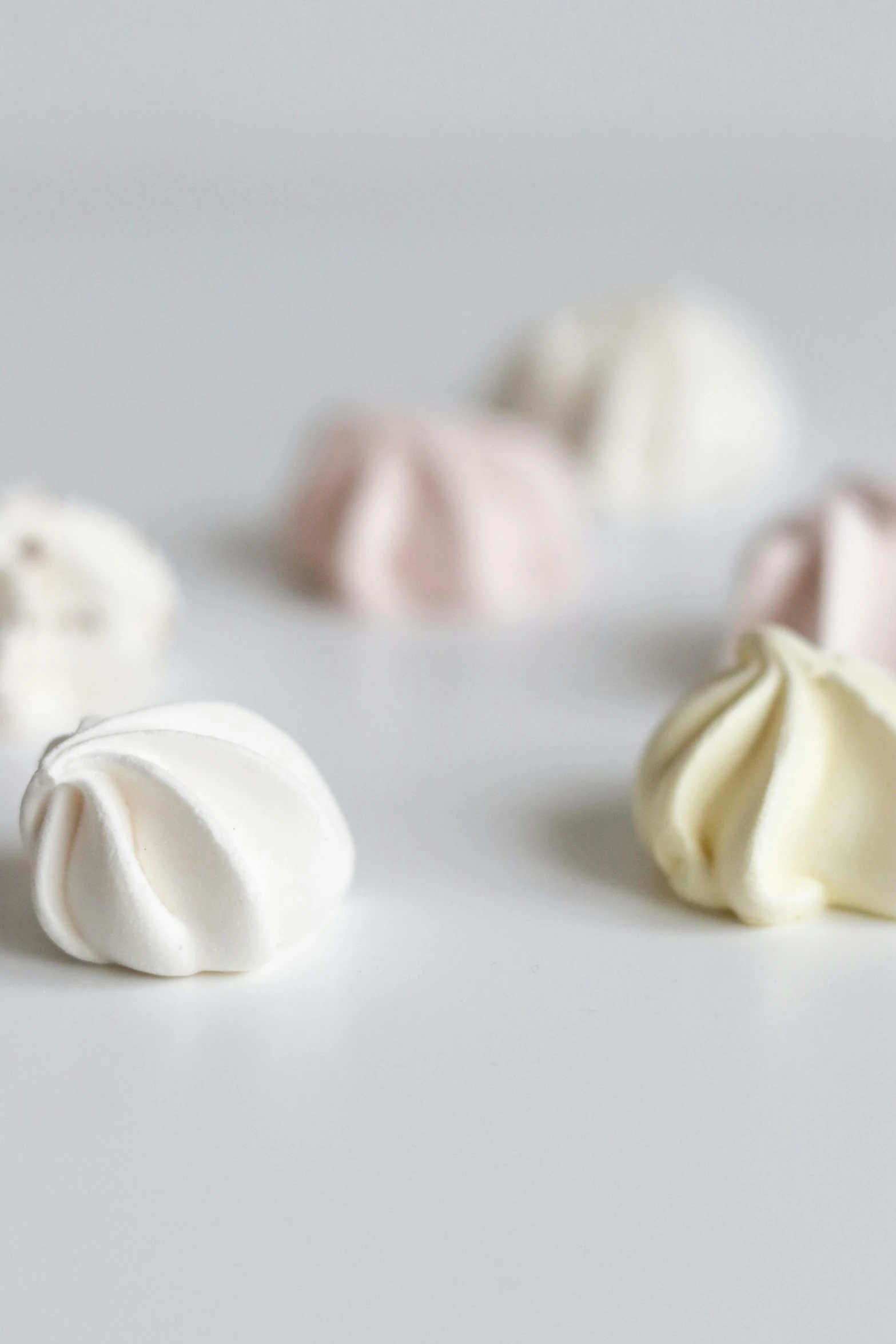 a close up of marshmallows on a white surface, by Sylvia Wishart, baroque, steamed buns, 3 colours, whipped cream, skyline