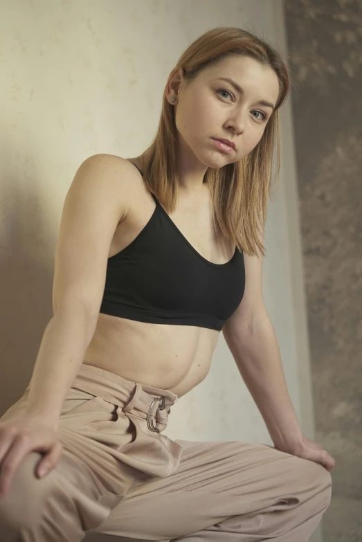 a woman in a black top and tan pants, a colorized photo, inspired by Elsa Bleda, trending on pexels, sport bra, 🤤 girl portrait, good young girl, thoughtful pose