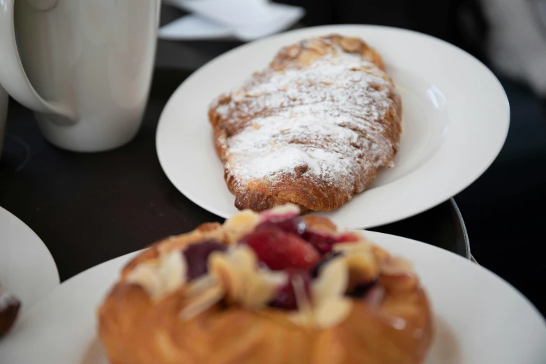 a table topped with plates of pastries covered in powdered sugar, inspired by Richmond Barthé, unsplash, breakfast, high quality photo, manuka, italian