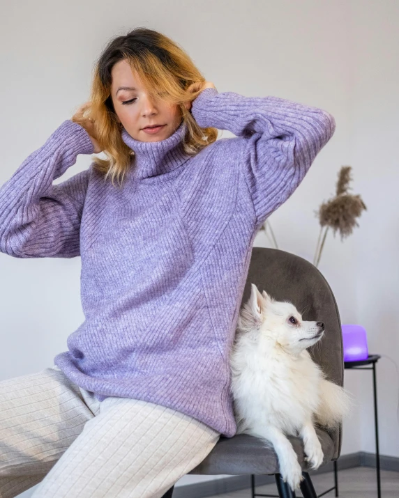 a woman sitting on a chair with a dog, a portrait, by Julia Pishtar, pexels contest winner, happening, wearing turtleneck, lilac, gif, wearing an oversized sweater