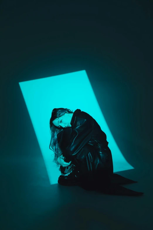 a woman sitting in front of a blue light, an album cover, unsplash, conceptual art, wearing black clothes and cape, sitting on the floor, cyan dimensional light, krystal