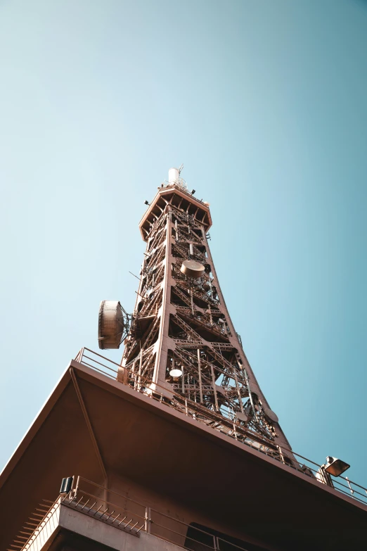 a tall tower sitting on top of a building, flat metal antenna, brown, industrial colours, intricate image