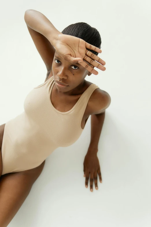 a woman in a bodysuit posing for a picture, beige cream natural muted tones, top down angle, curated collections, young black woman