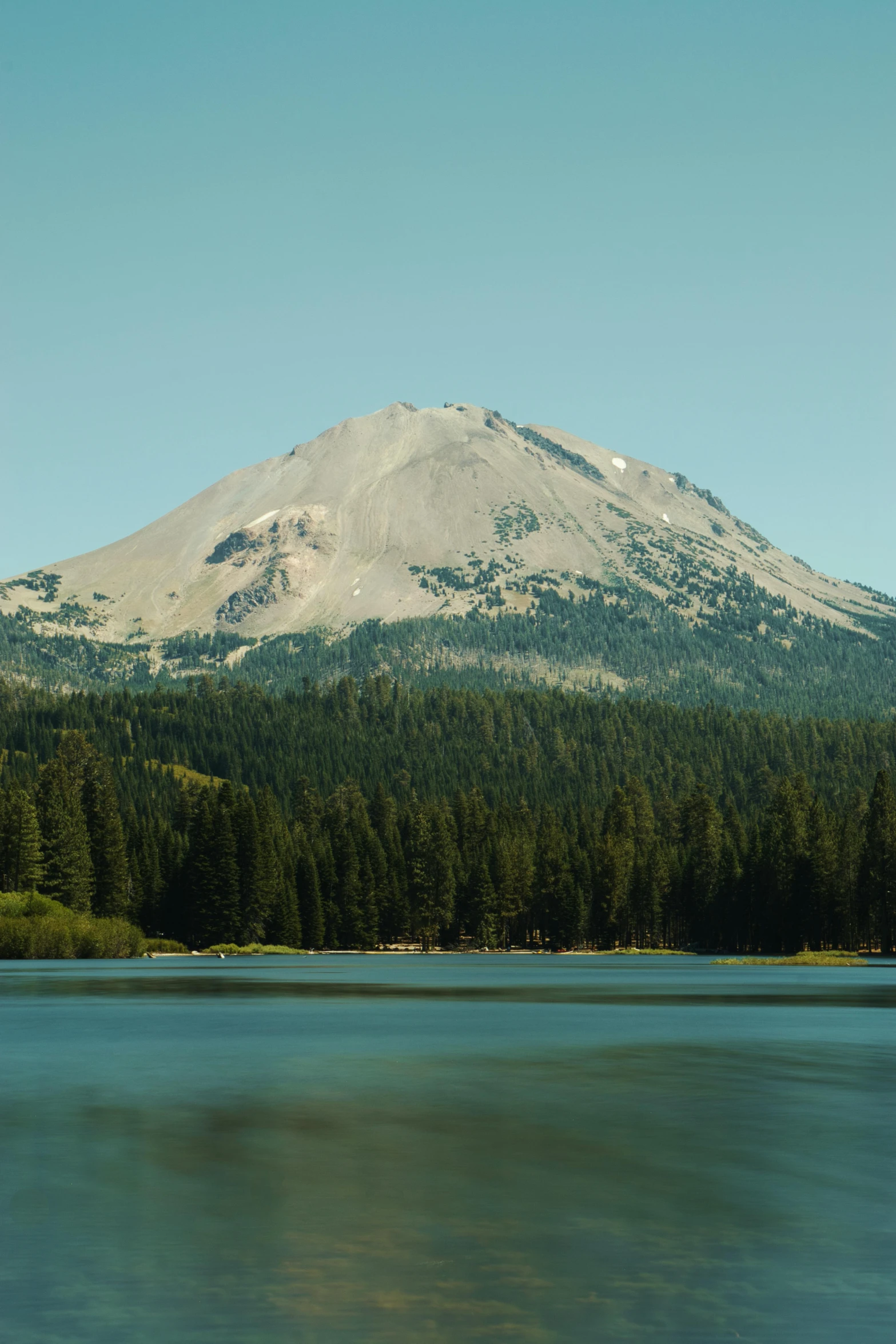 a body of water with a mountain in the background, forest with lake, california, volcano setting, promo image