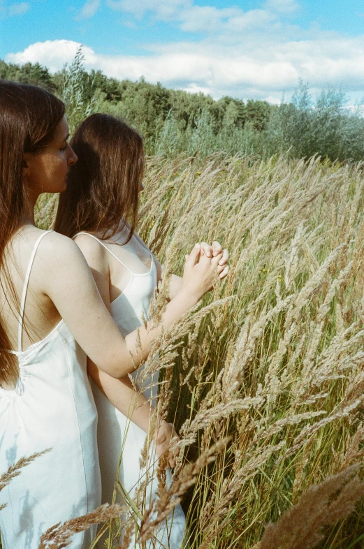 two women standing in a field of tall grass, inspired by Elsa Bleda, renaissance, wearing white camisole, ignant, high angle shot, holding close