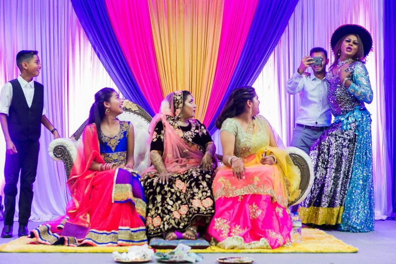 a group of people sitting on top of a stage, a portrait, flickr, bride, brightly colored, indian, snapchat photo