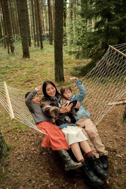 a family sitting in a hammock in the woods, a picture, by Jaakko Mattila, pexels contest winner, denim, [ cinematic, 8 k. elegant, phone photo