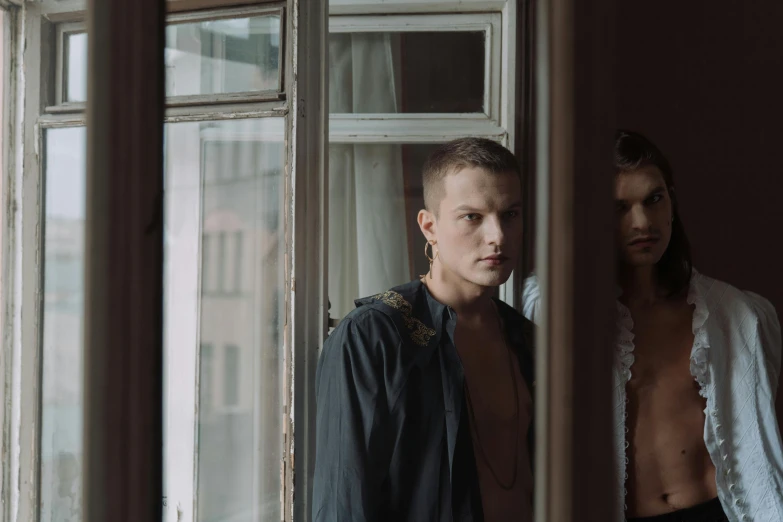 a man and a woman standing in front of a window, by Emma Andijewska, nonbinary model, vitalik buterin, looking into the camera, leaving a room