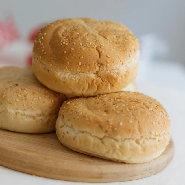 a pile of buns sitting on top of a wooden cutting board, hurufiyya, luscious patty with sesame seeds, 6 pack, soft skin, sandstone