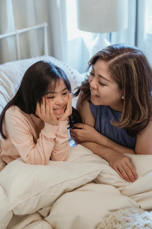 a woman and a little girl laying in bed, pexels contest winner, incoherents, young asian girl, talking, lesbian, cindy avelino