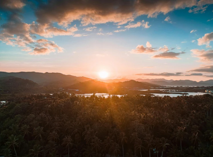 a large body of water surrounded by trees, by Tobias Stimmer, pexels contest winner, sumatraism, sun sunset, overlooking a valley with trees, thumbnail, golden hour in boracay