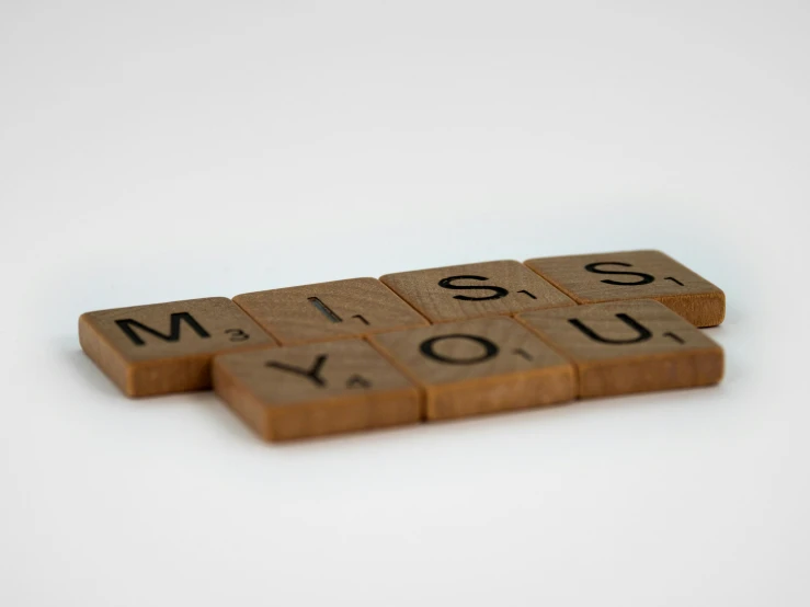 scrabbles spelling i miss you on a white surface, a picture, by Emma Andijewska, pexels, visual art, brown, panels, 1 2 9 7, mint