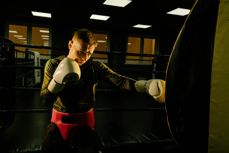 a man standing next to a punching bag, pexels contest winner, sparring, ringflash lighting, profile image, thumbnail