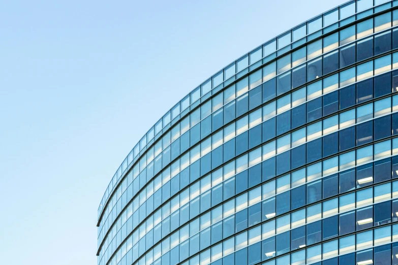 a very tall building with a lot of windows, pexels contest winner, curved lines, sky blue, corner office background, 2045