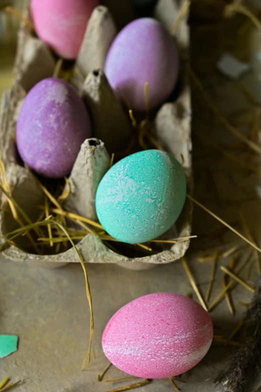 a carton of eggs sitting on top of a table, magical sparkling colored dust, mauve and cinnabar and cyan, soft cracks, chalked