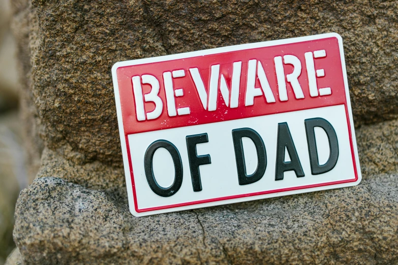 a red and white sign that says beware of dad, ad image, fatherly, square, demur