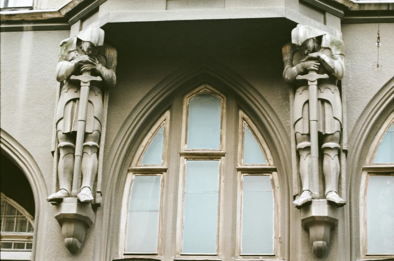 a clock mounted to the side of a building, a statue, unsplash, international gothic, bay window, 1990s photograph, high arches, faded worn