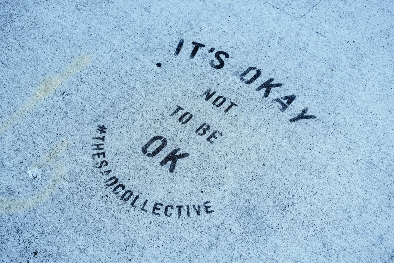 it's okay not to be ok written on the sidewalk, concrete art, collaborative artwork, outlive streetwear collection, promo photo, panel