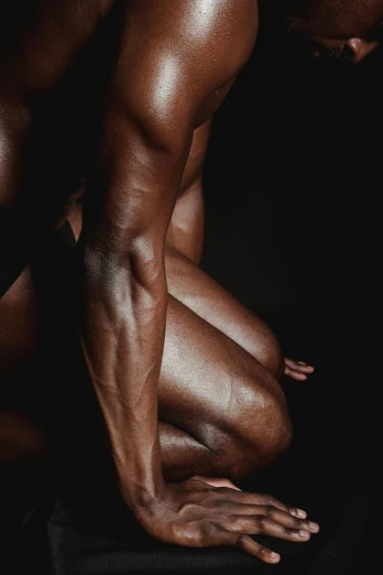 a man kneeling down with his hands on his knees, an album cover, inspired by Robert Mapplethorpe, pexels contest winner, bodybuilder physique, dark brown skin, legs intertwined, skin detail
