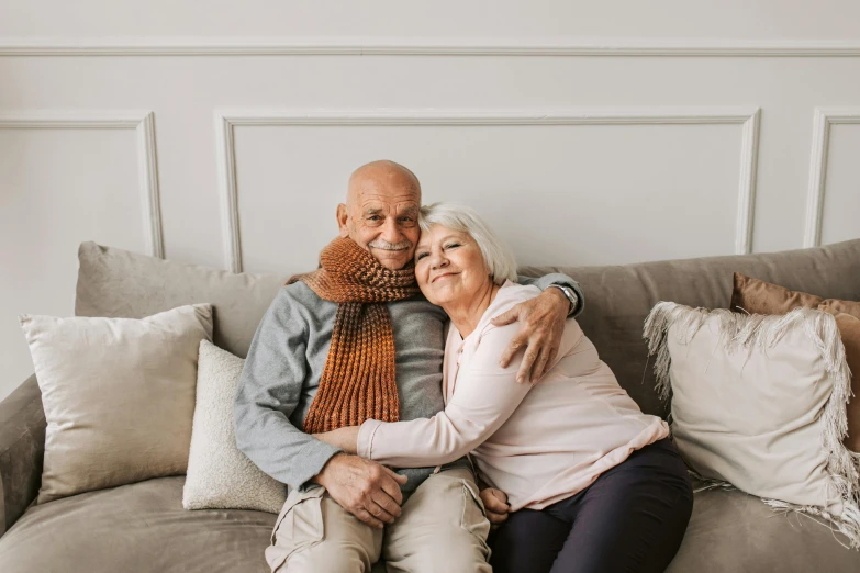 a man and a woman sitting on a couch, pexels contest winner, photorealism, older male, hugging, premium quality, winter season