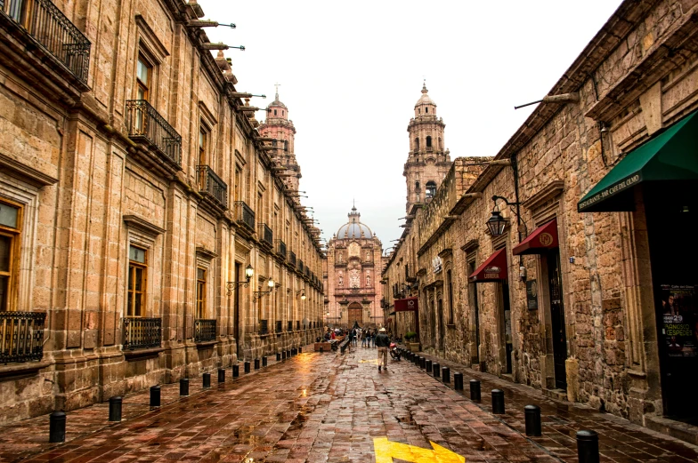 a yellow umbrella sitting in the middle of a cobblestone street, pexels contest winner, downtown mexico, black domes and spires, gas lanterns, pink marble building