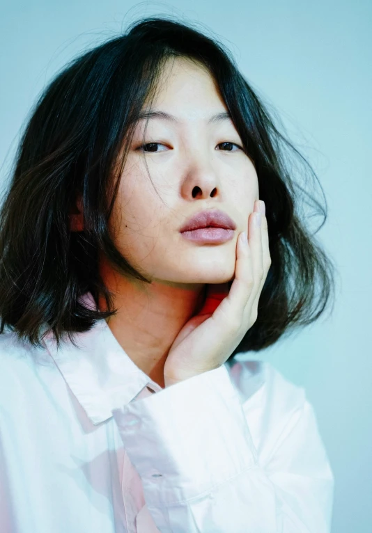 a woman in a white shirt posing for a picture, an album cover, inspired by Jung Park, trending on unsplash, hyperrealism, asian face, thoughtful ), gregg araki, hand on cheek