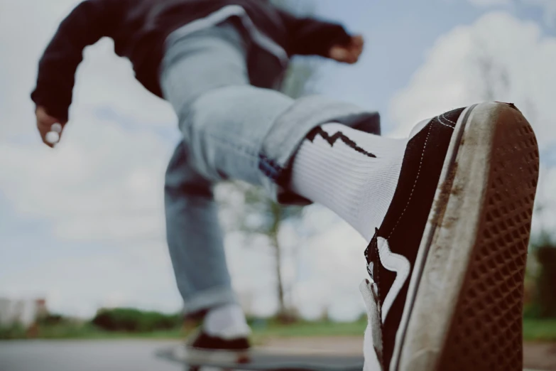 a man riding a skateboard down a street, by Niko Henrichon, pexels contest winner, realism, socks, close up shot from the side, off - white collection, jumping towards viewer