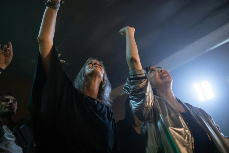 a group of people standing on top of a stage, pexels contest winner, happening, silver hair so long, underground party, cheering, two women