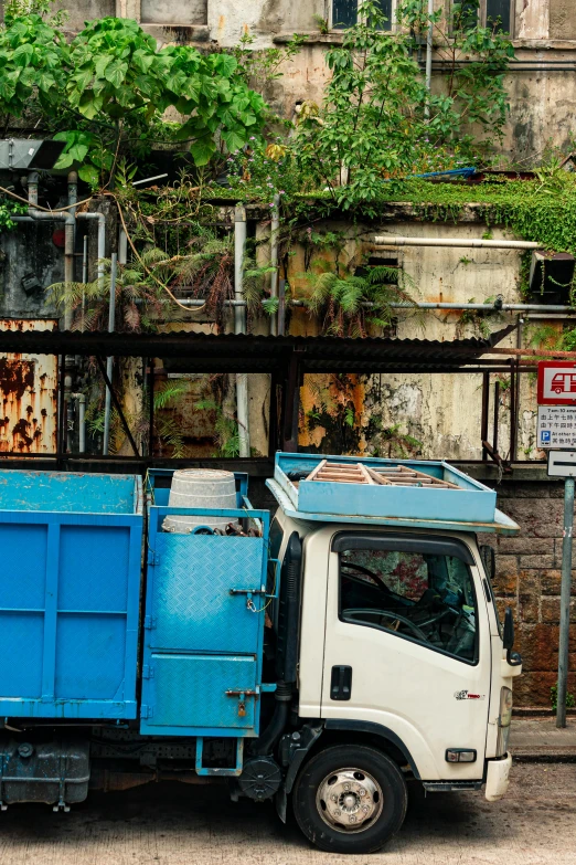 a blue and white truck parked in front of a building, flickr, scattered rubbish and debris, in sci - fi mumbai, panoramic shot, street signs