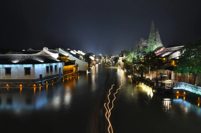 a river running through a town at night, by Shi Rui, pexels contest winner, fan favorite, canals, cai guo-qiang, quaint village