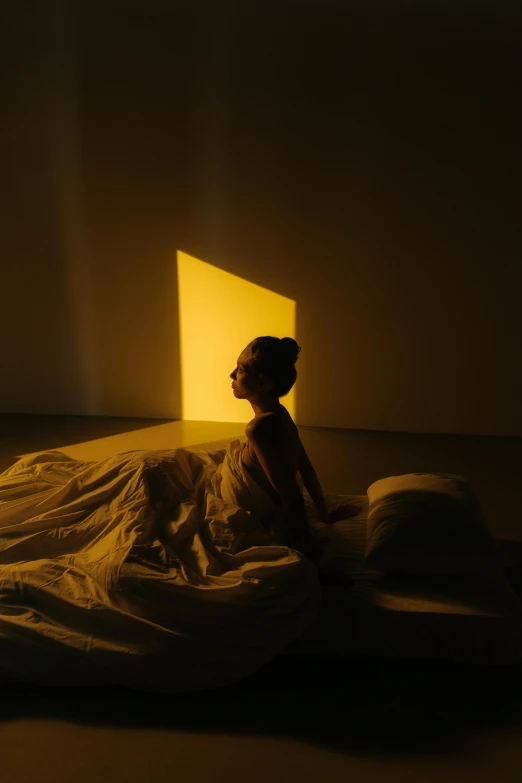 a woman sitting on a bed in a dimly lit room, an album cover, inspired by Fei Danxu, light and space, yellow aura, shadow play, ignant, profile pic