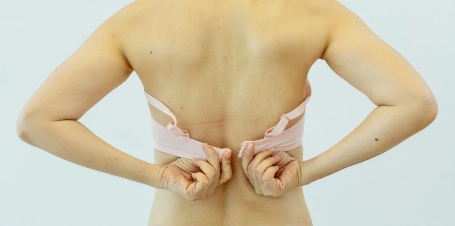 the back of a woman with her hands on her hips, by Ellen Gallagher, unsplash, sōsaku hanga, bandage taped fists, pink, silicone skin, medical image