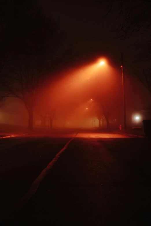 a street light in the middle of a foggy night, by Andrew Domachowski, tonalism, award - winning photo ”, red and orange glow, eerie ”