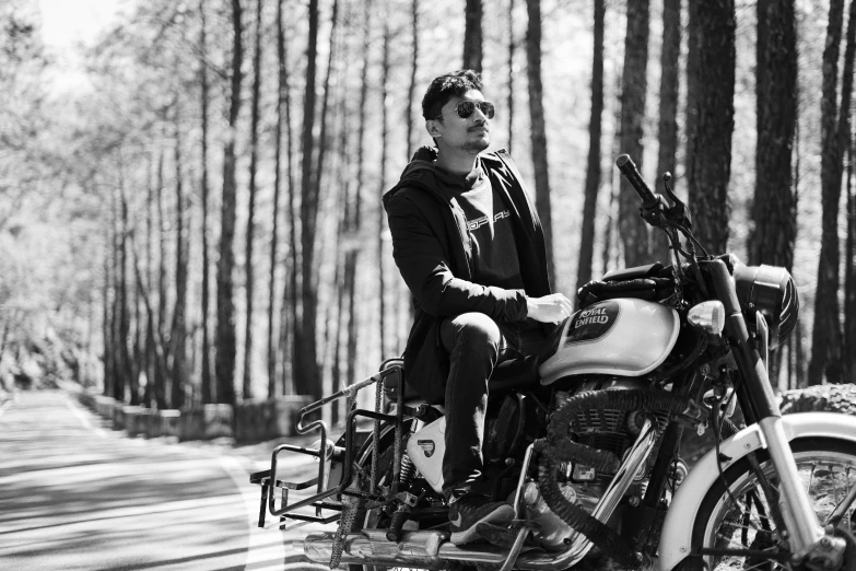 a black and white photo of a man sitting on a motorcycle, a black and white photo, pexels, pine forests, declan mckenna, red hood cosplay, donglu yu