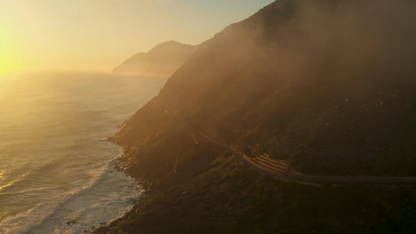 an aerial view of a winding road next to the ocean, unsplash contest winner, australian tonalism, sun rises between two mountains, cinematic screenshot gta 5, south african coast, smoke behind