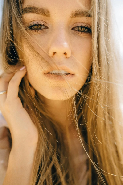 a close up of a woman with long hair, inspired by Elsa Bleda, trending on pexels, light stubble, sunbathed skin, blonde girl, hand over mouth