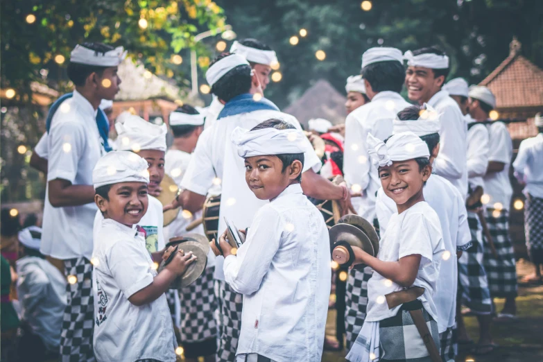 a group of young boys standing next to each other, pexels contest winner, happening, wearing traditional garb, white sarong, avatar image, bells