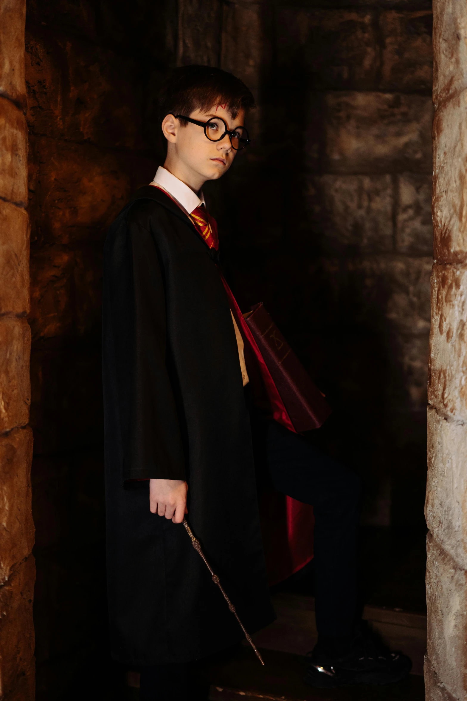 a young man dressed in a harry potter costume, pexels, in a dungeon background, 1 6 years old, ( ( theatrical ) ), promo image