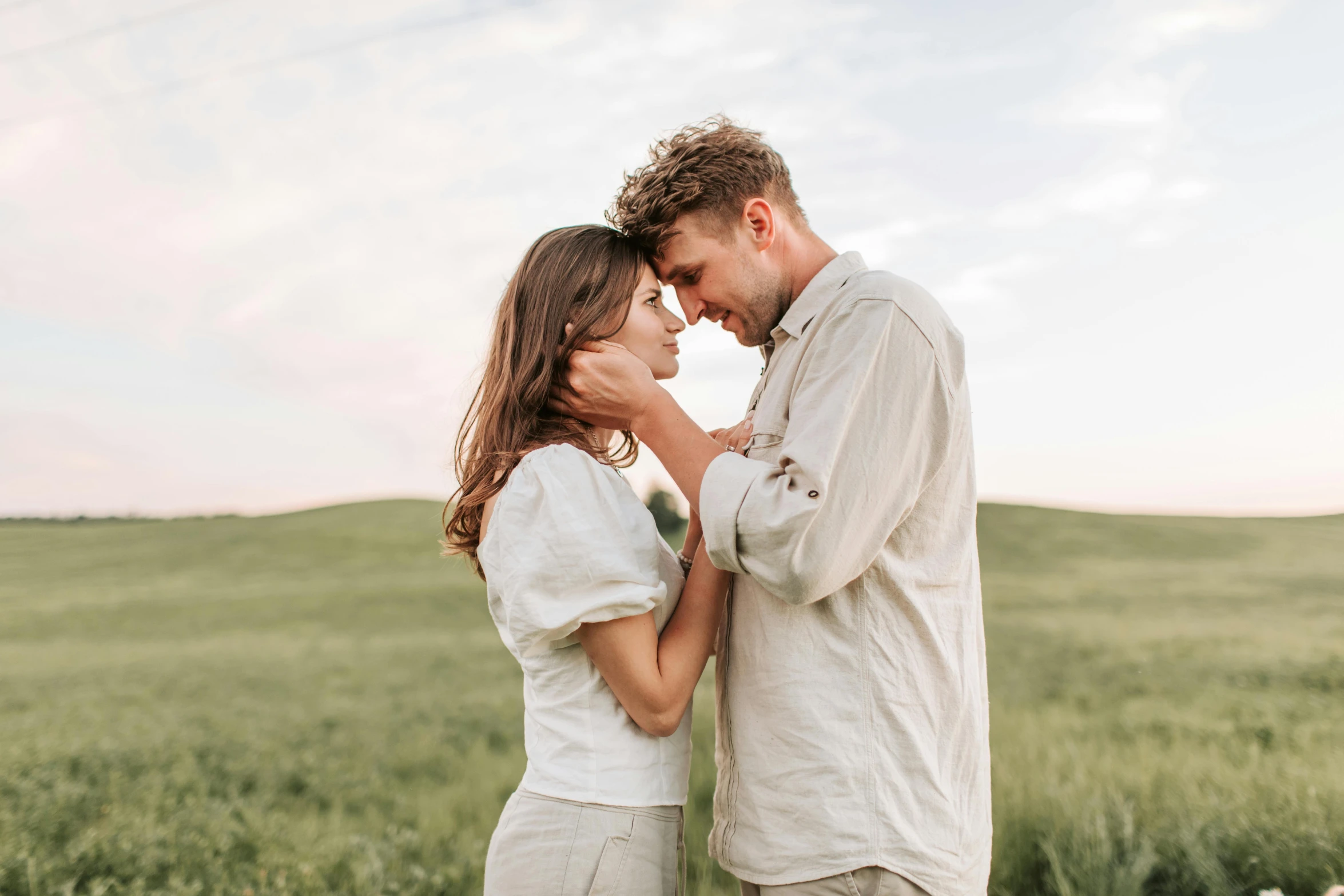 a man and woman standing next to each other in a field, pexels contest winner, wearing a linen shirt, romance, background image, sydney hanson