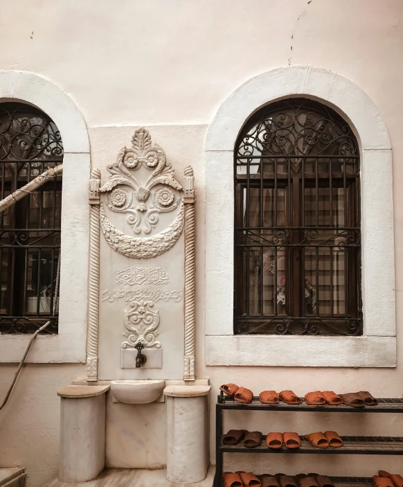 a couple of windows sitting on the side of a building, a marble sculpture, inspired by Riad Beyrouti, trending on unsplash, water fountain, decorated with soviet motifs, white marble interior photograph, brown