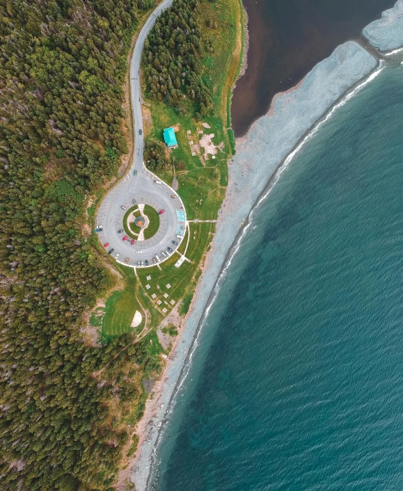 a large body of water next to a forest, by Terese Nielsen, pexels contest winner, land art, built around ocean, 2 5 6 x 2 5 6 pixels, helipad, a park