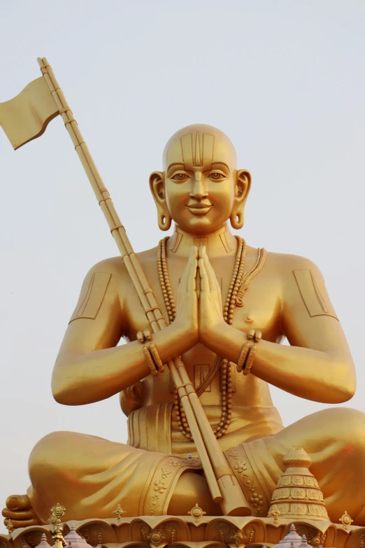 a large statue of a man holding a flag, a statue, inspired by Ram Chandra Shukla, samikshavad, sitting cross-legged, 2 5 6 x 2 5 6 pixels, mustard, large temples