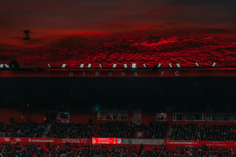 a group of people standing on top of a soccer field, a picture, inspired by Elsa Bleda, pexels contest winner, crimson red aura, manchester, demonic atmosphere, banner