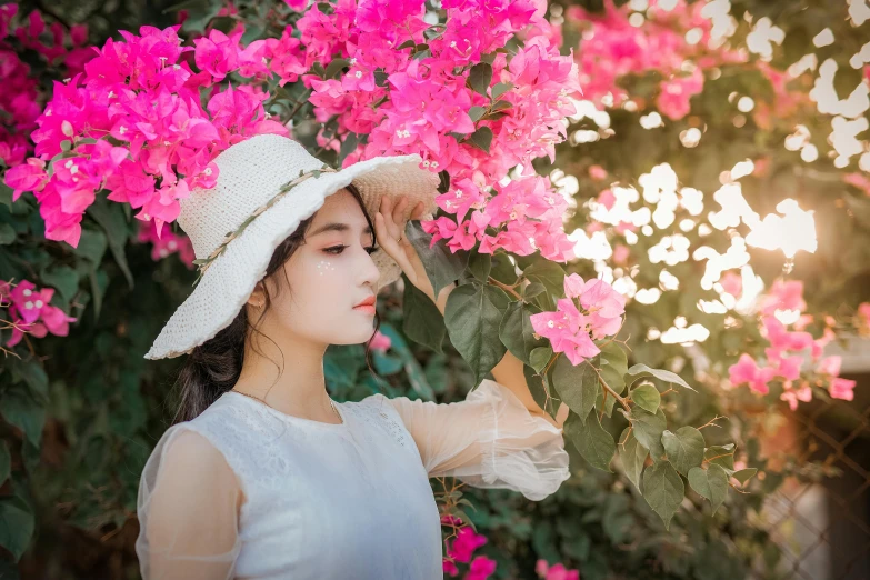 a woman wearing a white hat standing in front of pink flowers, inspired by Huang Ji, pexels contest winner, aestheticism, avatar image, beautiful asian girl, bougainvillea, 1 2 9 7