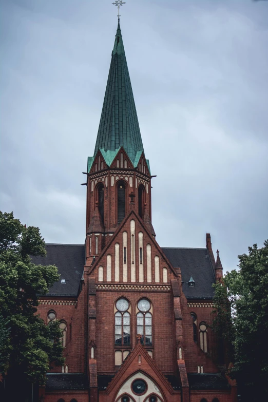 a church with a steeple on a cloudy day, an album cover, by Harry Haenigsen, unsplash, hannover, exterior, front face, marilyn church h