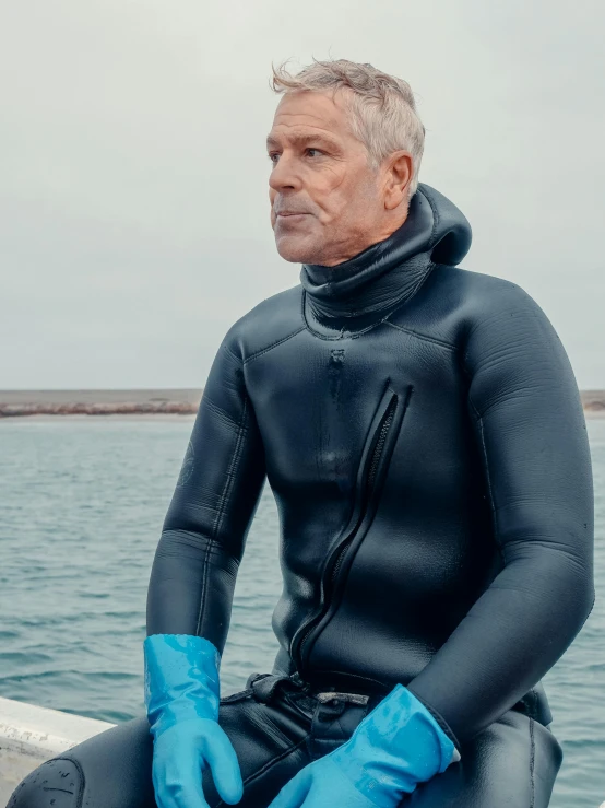 a man in a wet suit sitting on a boat, jeffery epstein, silicone skin, paul barson, 2019 trending photo