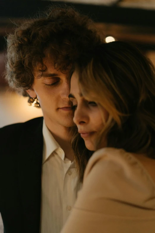 a man and a woman standing next to each other, an album cover, by Sara Saftleven, trending on pexels, timothee chalamet, intimate lighting, headshot, lightly dressed