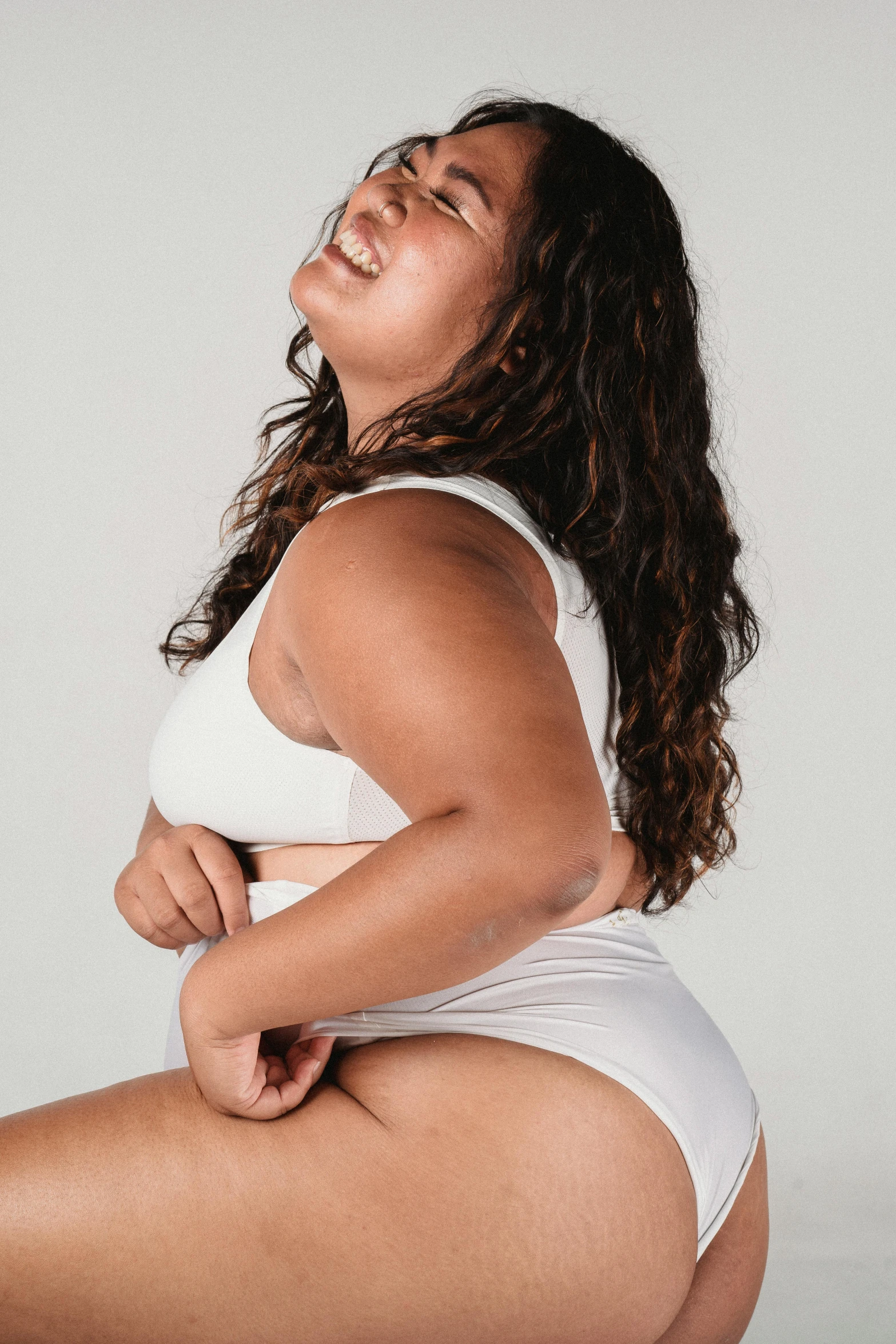 a woman in a white bikini posing for a picture, an album cover, pexels contest winner, overweight, head bent back in laughter, profile image, bra and shorts streetwear